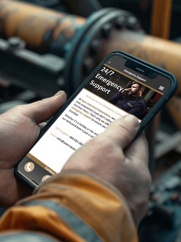 Close-up of a mobile phone displaying the Apex Mobile App 24/7 emergency support page, held by someone in a high-visibility safety jacket with blurred industrial pipes in the background.