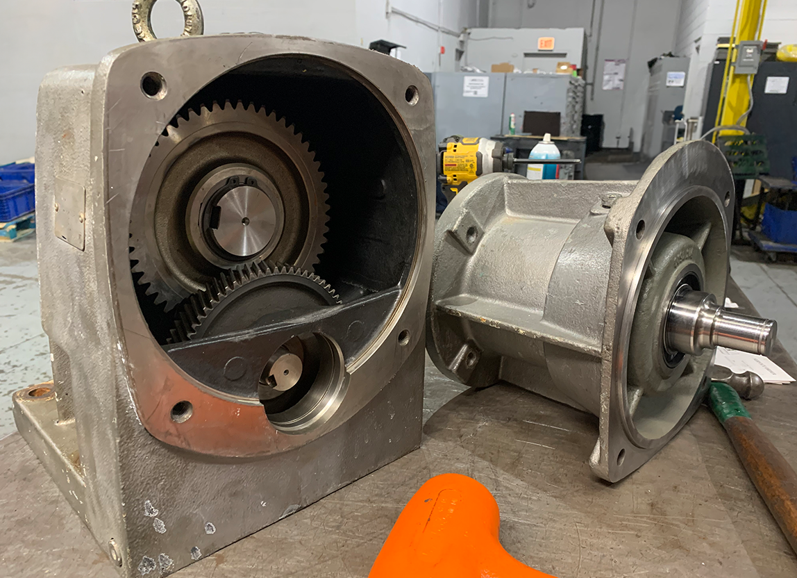 Close-up of a small disassembled gearbox at Apex Industrial Automation, ready for repair.