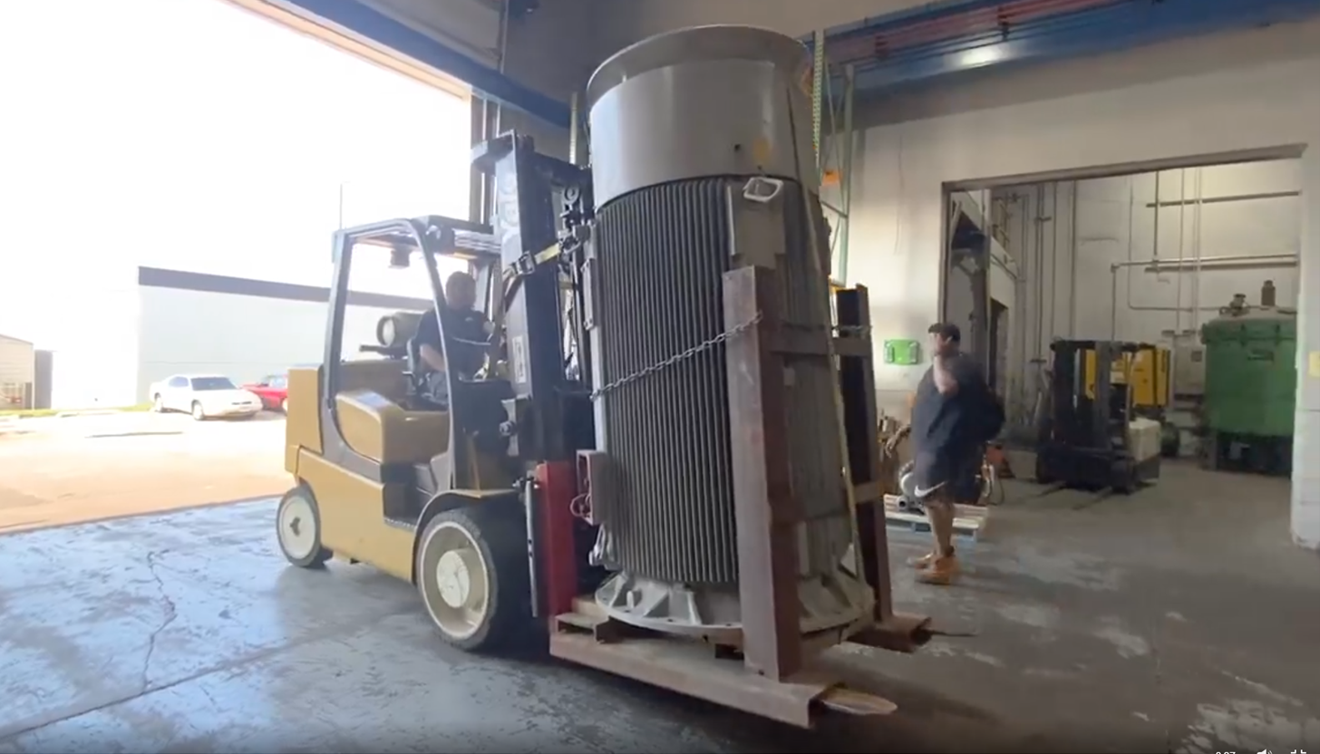 1000 HP AC Siemens electric motor being transported on a forklift into Apex Industrial Automation's repair shop for servicing.