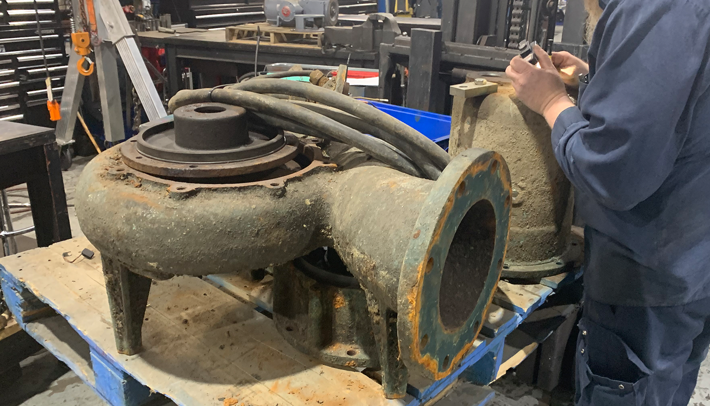 Large industrial pump on a workbench at Apex Industrial Automation being disassembled for cleaning and repair.