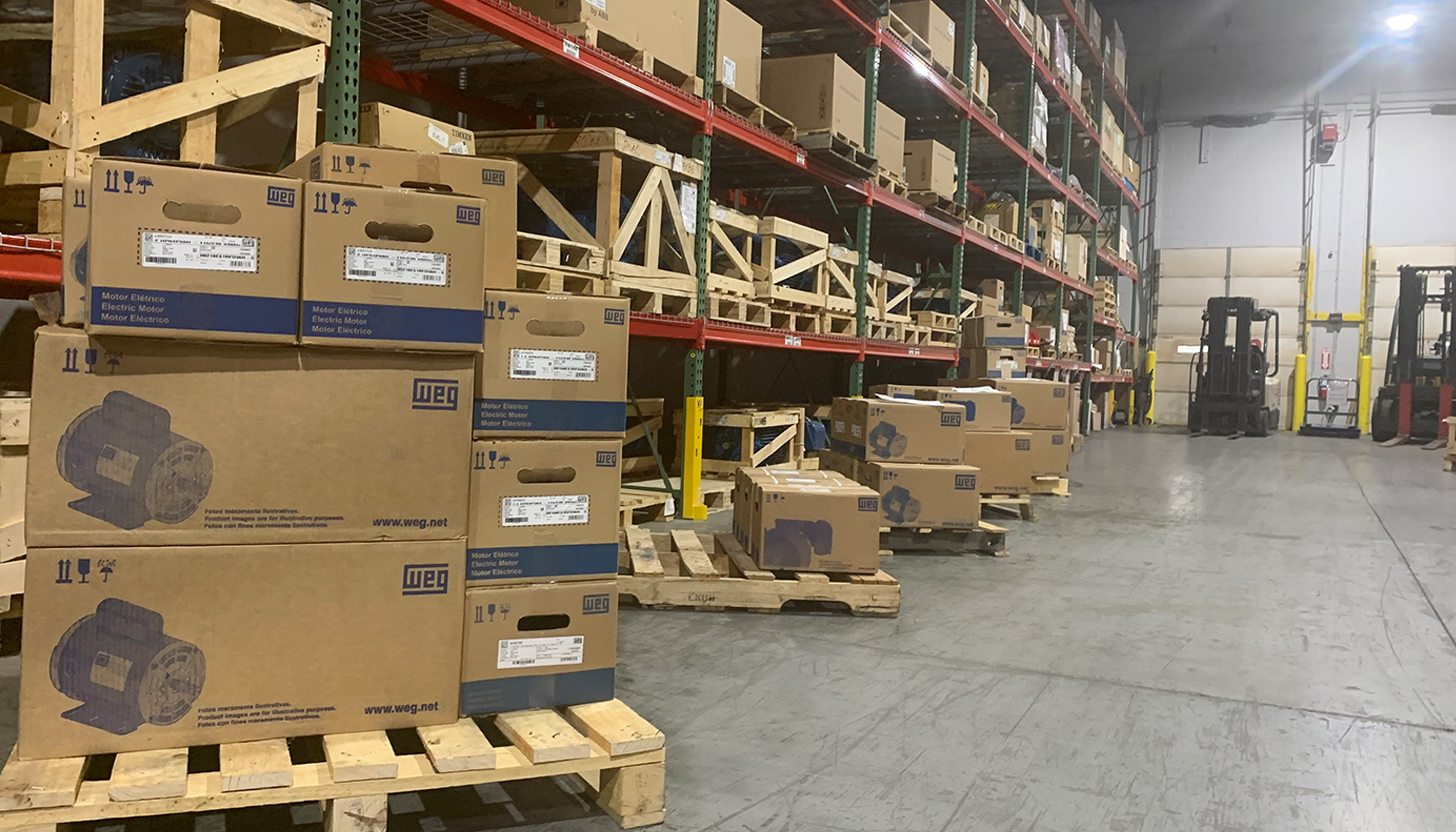Close-up view of shelves stocked with hundreds of WEG industrial electric motors at Apex Industrial Automation's warehouse.